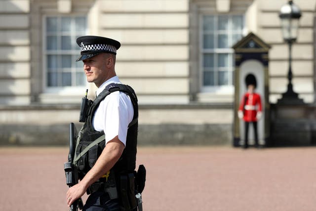 A police officer patrols within the grounds of Buckingham Palace in London