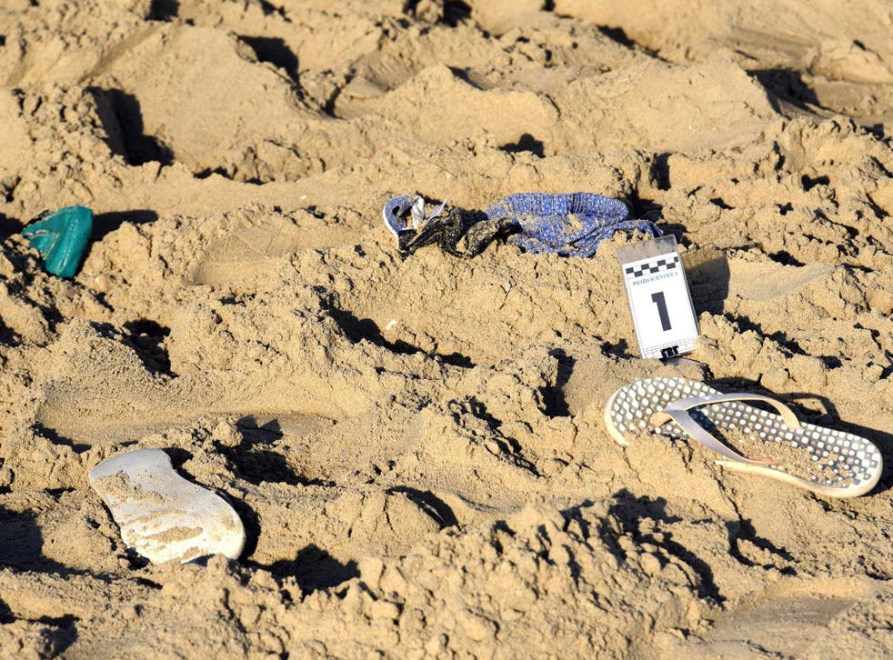 A pair of beach slippers lie on the sand where a suspected gang rape of a Polish tourist and the beating of her partner took place in Rimini, Italy