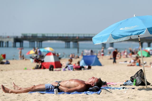 People sunbathe on Boscombe beach in Dorset