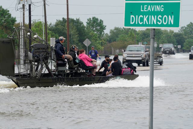 People are rescued by airboat as they evacuate from flood waters after Hurricane Harvey in Dickinson, Texas, in August
