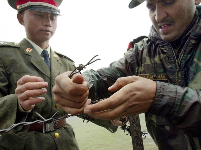 A Chinese soldier and an Indian soldier constructing a barbed wire