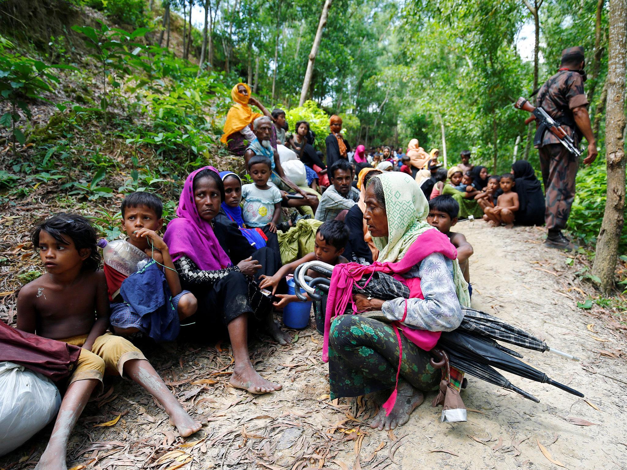 Rohingya Muslims sit on the Bangladesh border as they are restricted by the members of Border Guards Bangladesh (BGB) from going further inside Bangladesh
