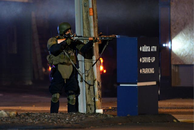 A state trooper aims his gun at protesters in Ferguson, Missouri, on 25 November 25 2014 during a demonstration one day after violent protests and looting following the grand jury decision in the Michael Brown police shooting case