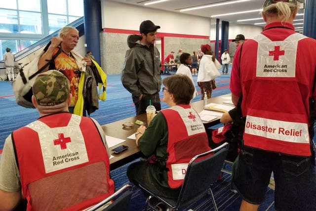 Evacuees arrive to seek shelter with Red Cross volunteers at the George Brown convention centre after flood waters of Hurricane Harvey forced them to leave their homes in Houston, Texas, on 27 August 201