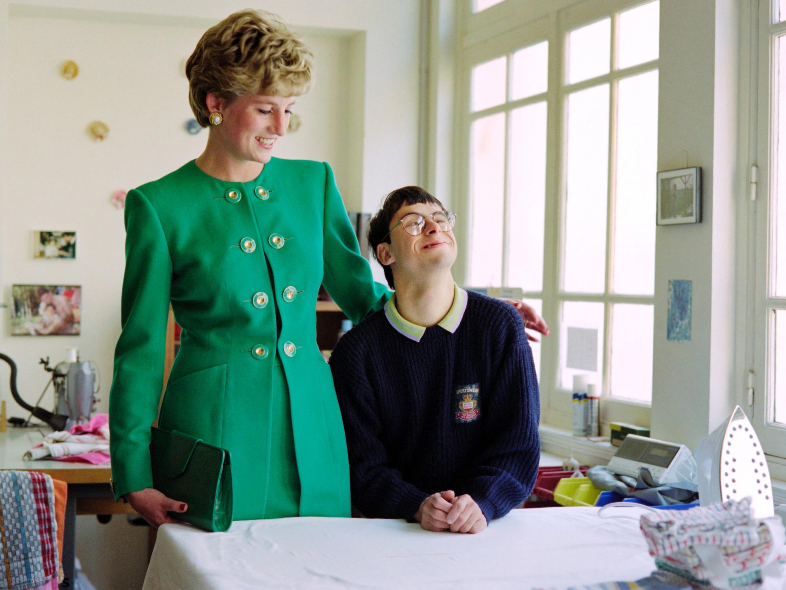 Diana listens to a young disabled boy on 13 November, 1992 during her visit to a home in Paris