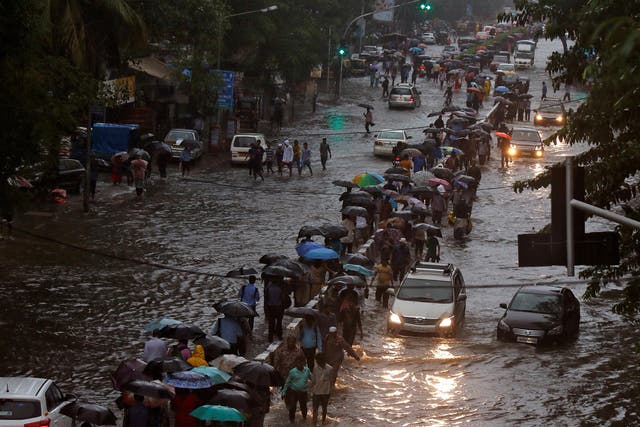 Commuters walk through water-logged roads after rains in Mumbai, India
