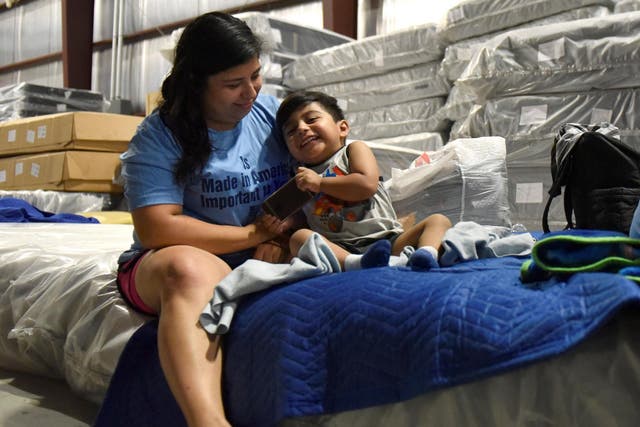 Maria Lopez plays with her son Rafael Lopez, 3, in the warehouse at Gallery Furniture where they have been staying after evacuating their flooded home over the weekend, in Houston, Texas