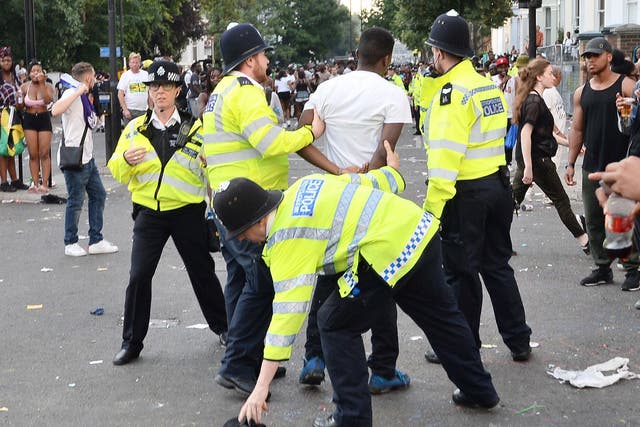 Police holding a man during the second and final day of the Notting Hill Carnival in west London