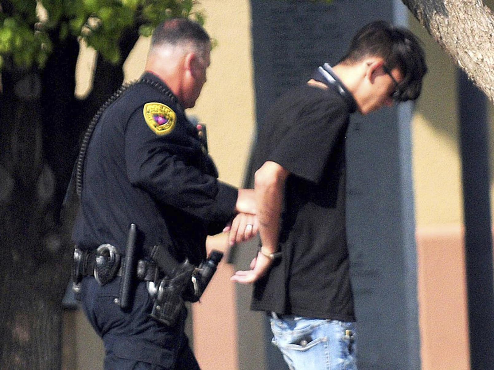 Police take a man into custody after a shooting at a public library in the eastern New Mexico community of Clovis