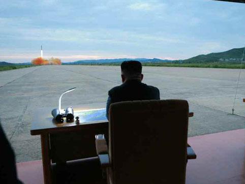 Mr Kim watches as the missile is launched (Rodong Sinmun)