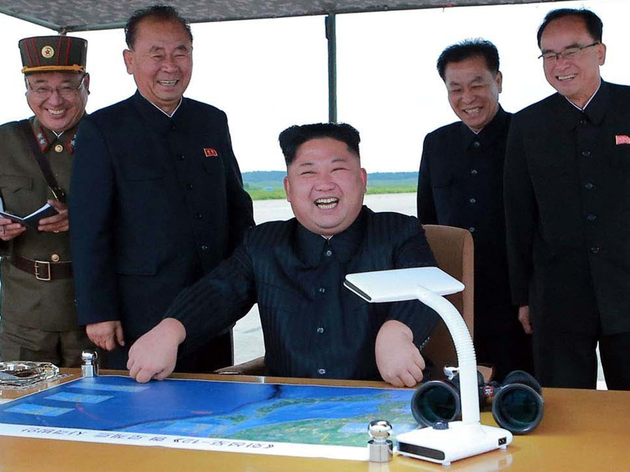 Kim Jong-un smiles as he inspects the test launch of a Hwasong-12 intermediate range missile in Pyongyang