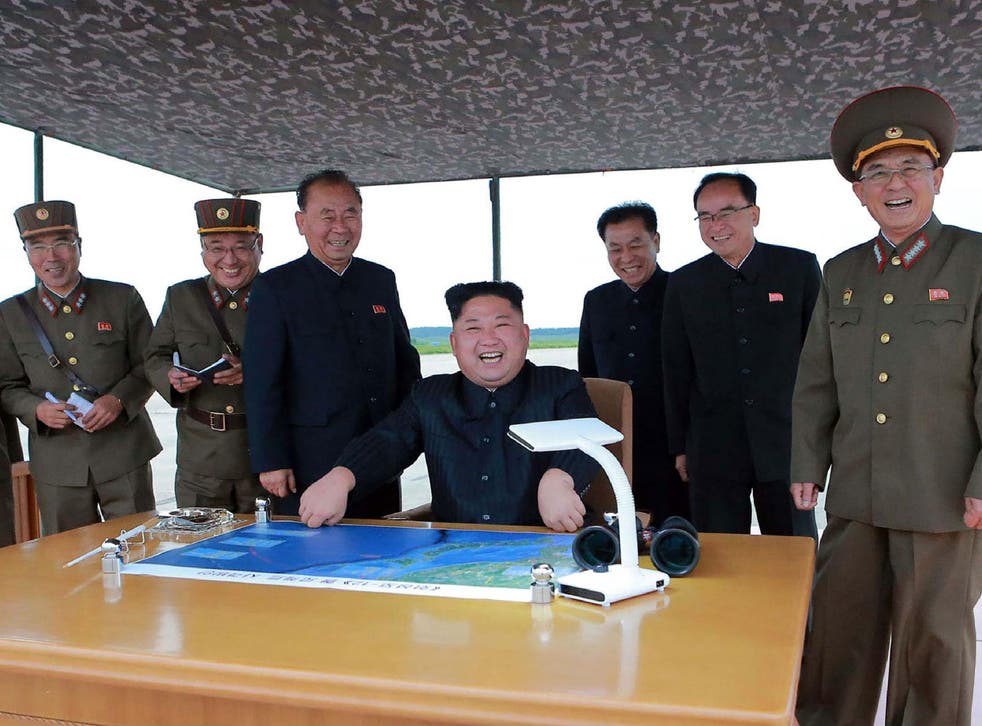 Kim Jong-Un laughs during the launch of a missile aimed over Japan