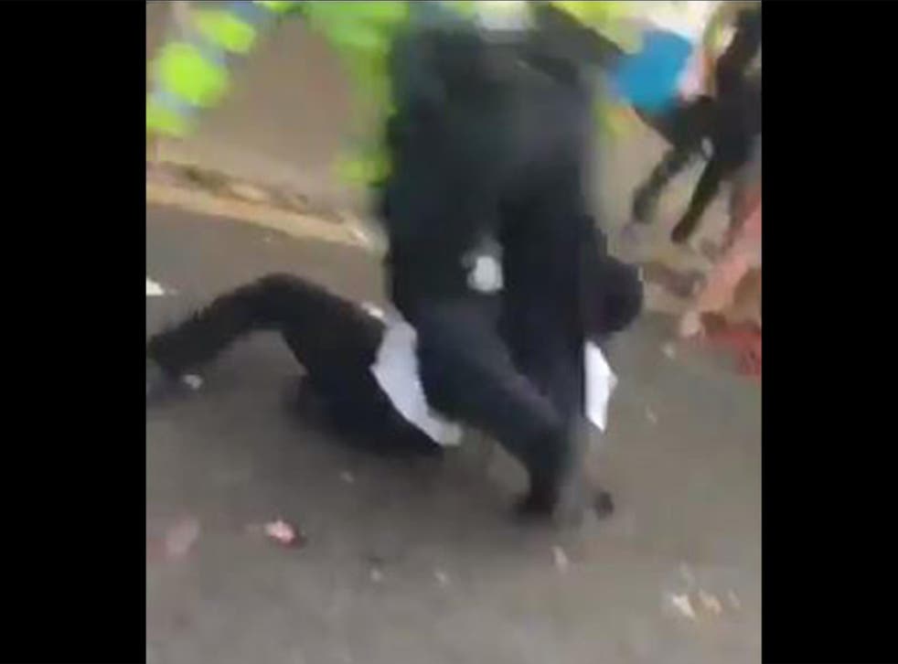 The man suddenly lies on the ground just as the officer reaches him, causing the policeman to tumble over him