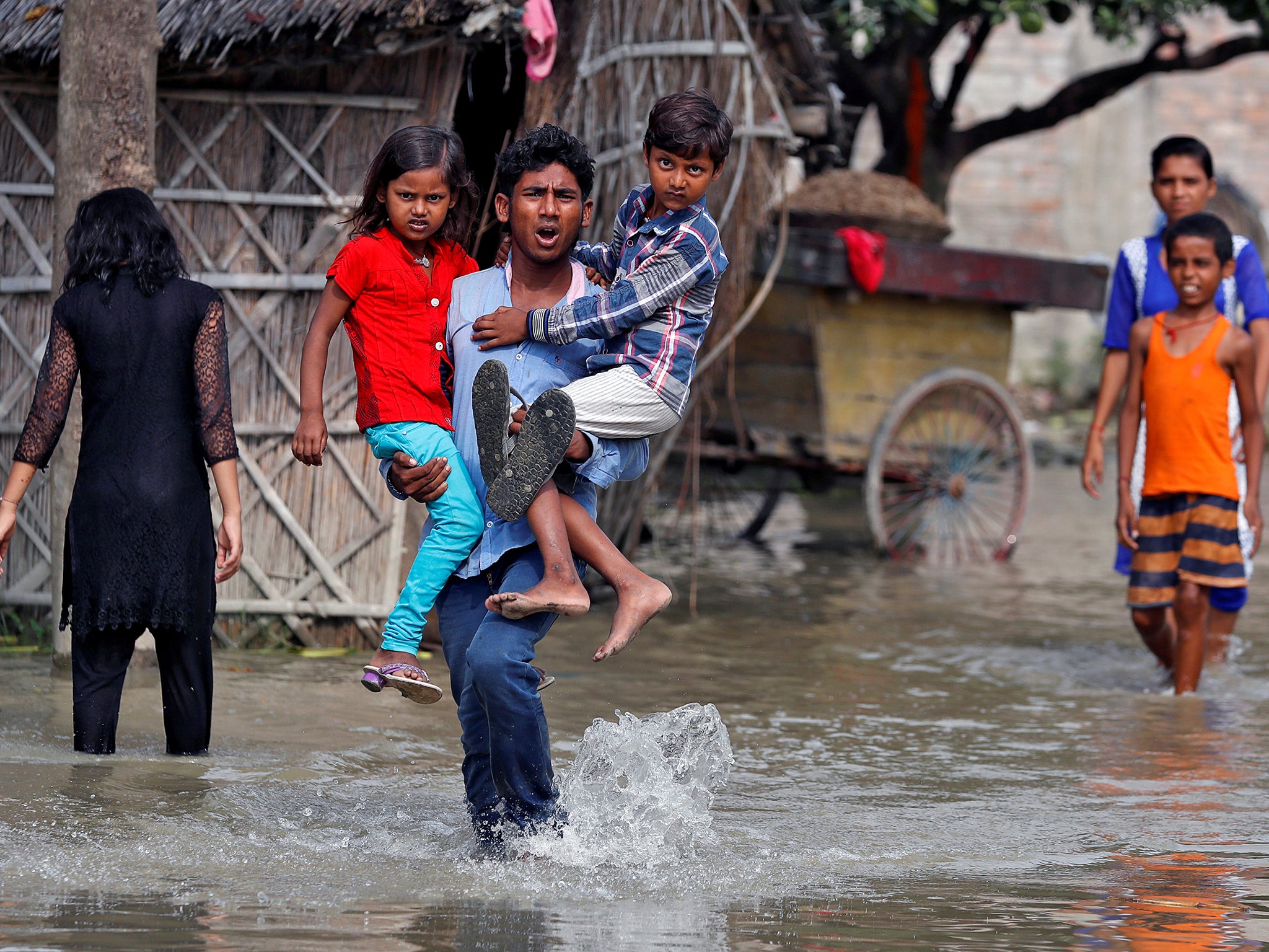 A man wades toward a rescue boat through a flooded village in the eastern state of Bihar, India