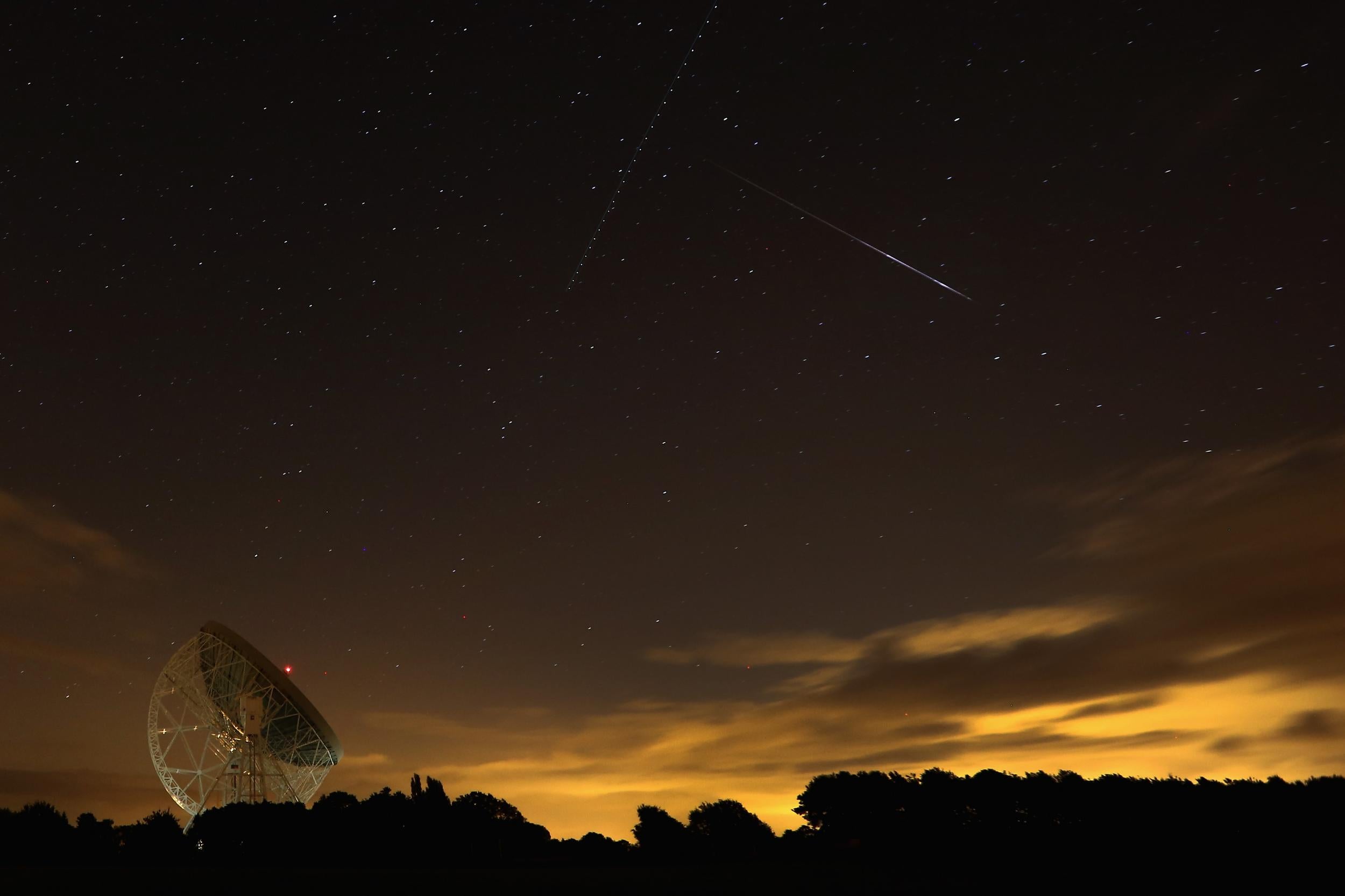 A Perseid meteor streaks across the sky over the Lovell Radio Telescope at Jodrell Bank