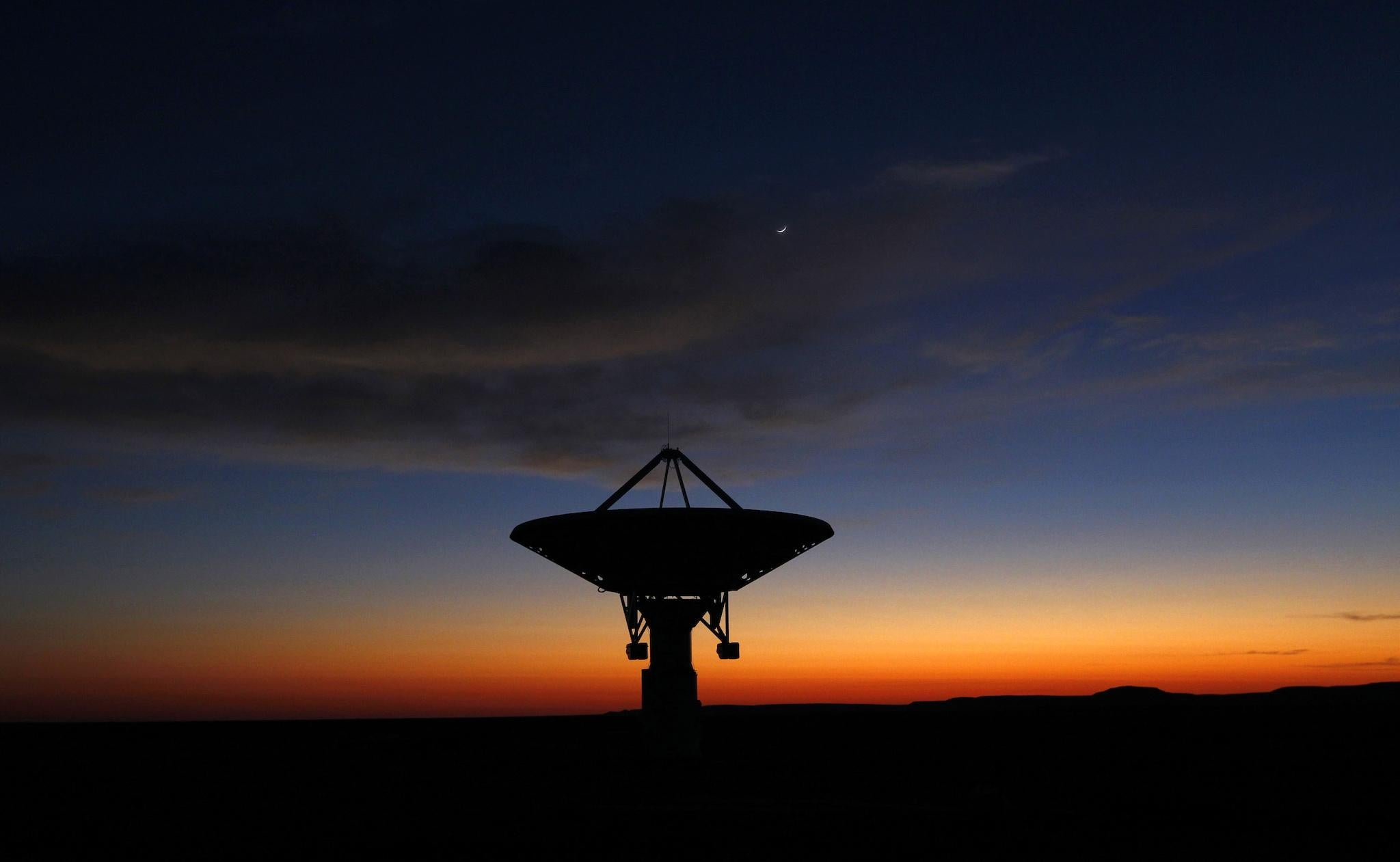 Dawn breaks over a radio telescope dish of the KAT-7 Array pointing skyward at the proposed South African site for the Square Kilometre Array (SKA) telescope