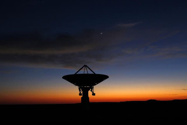 Dawn breaks over a radio telescope dish of the KAT-7 Array pointing skyward at the proposed South African site for the Square Kilometre Array (SKA) telescope