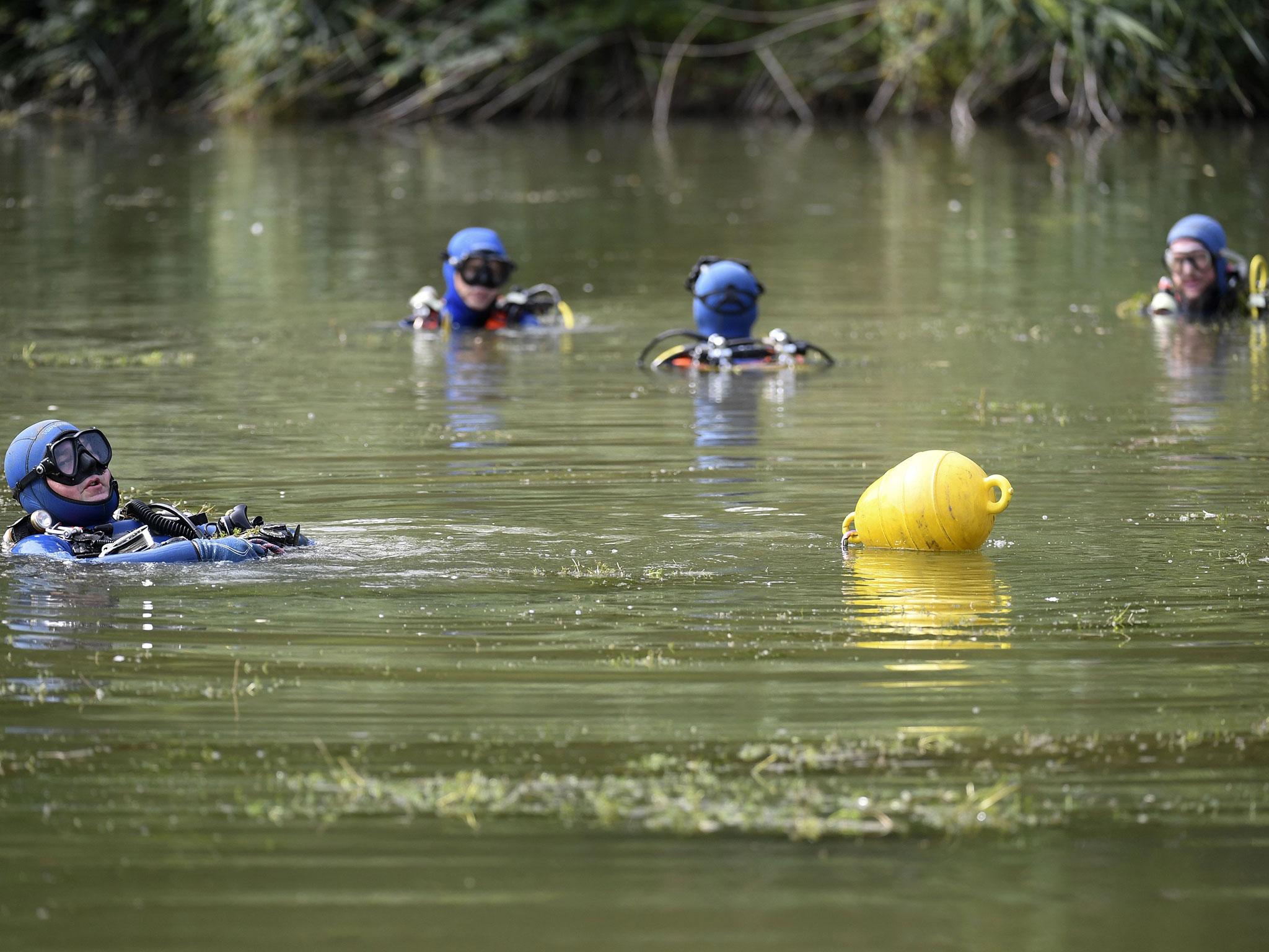 Divers of the French gendarmerie searched for evidence in a pond near Pont-de-Beauvoisin