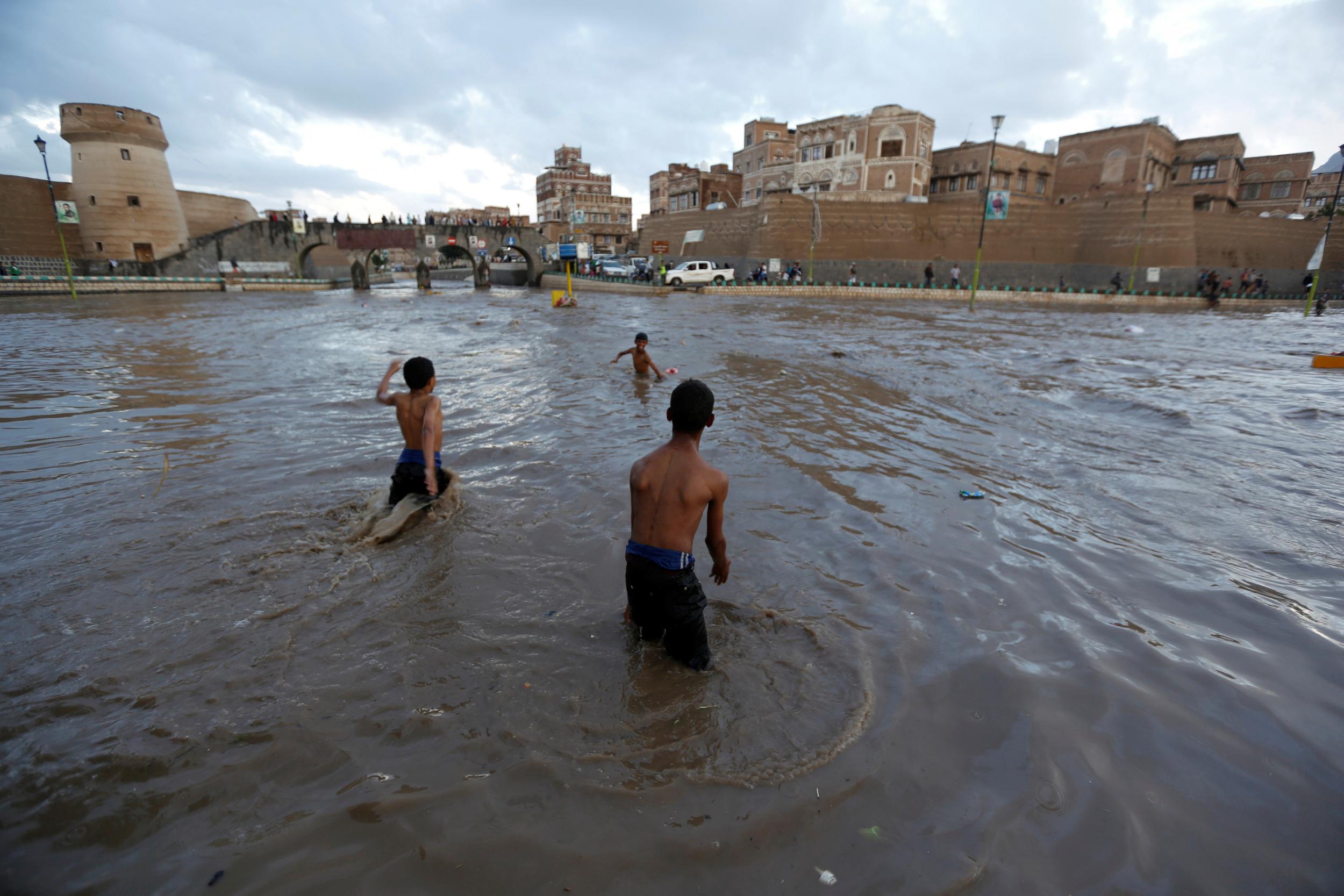 Boys play in flood water in the Old City of Sanaa, Yemen in this file photo from 2 August 2016