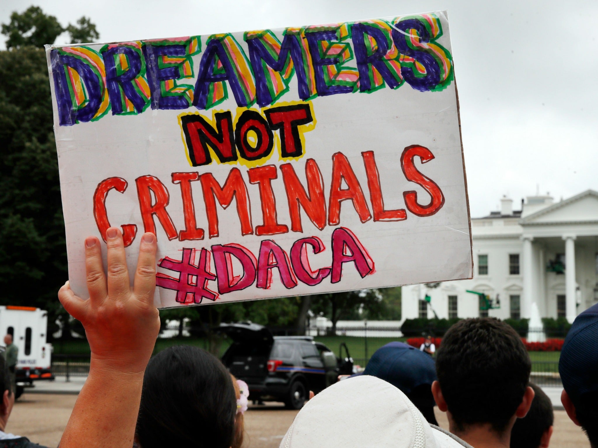A woman holds up a sign in support of Daca during an immigration reform rally at the White House in Washington