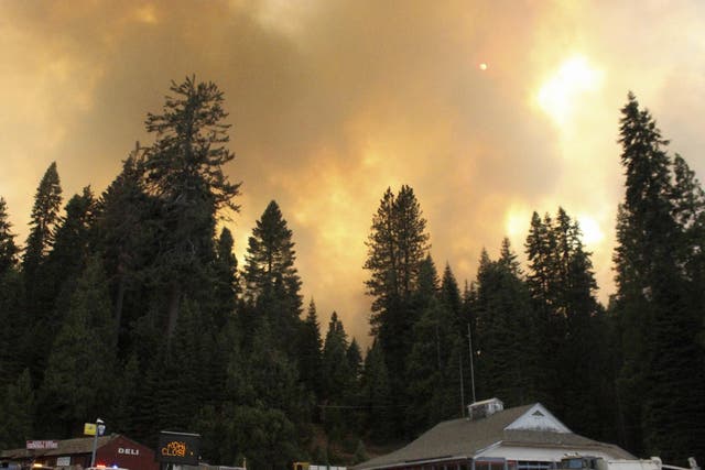 Smoke rises from a wildfire behind the Fish Camp General Store near Yosemite National Park, California