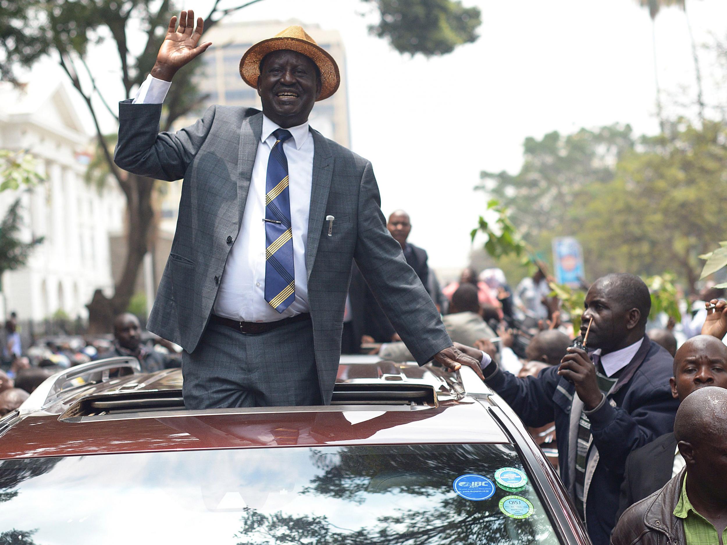 Kenyan opposition leader Raila Odinga waves at supporters as he leaves the Supreme Court