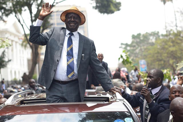 Kenyan opposition leader Raila Odinga waves at supporters as he leaves the Supreme Court
