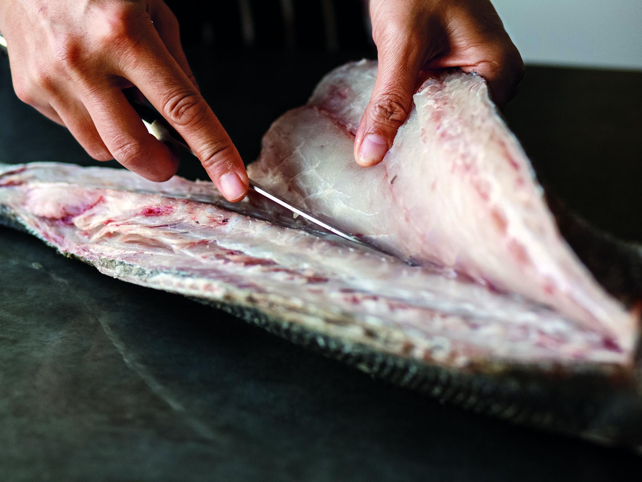 5. Open the incision and run the knife against the bones of the fish to start to separate the fillet from the rest of the fish. Keep the knife as close as possible to the bones so as not to waste any of the fillet