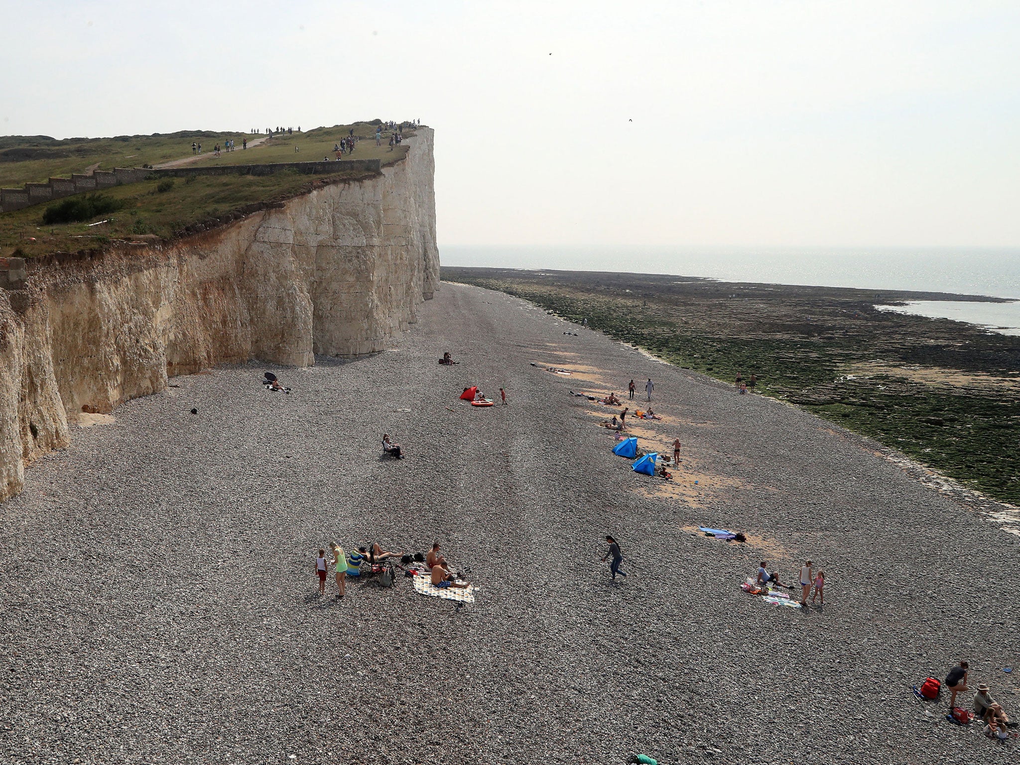 People on the beach at Birling Gap in Eastbourne, part of a stretch of coastline that was evacuated on Sunday after a chemical 'haze' left dozens of holidaymakers with streaming eyes, sore throats and vomiting