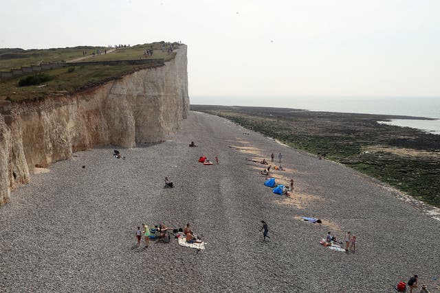 People on the beach at Birling Gap in Eastbourne, part of a stretch of coastline that was evacuated on Sunday after a chemical 'haze' left dozens of holidaymakers with streaming eyes, sore throats and vomiting