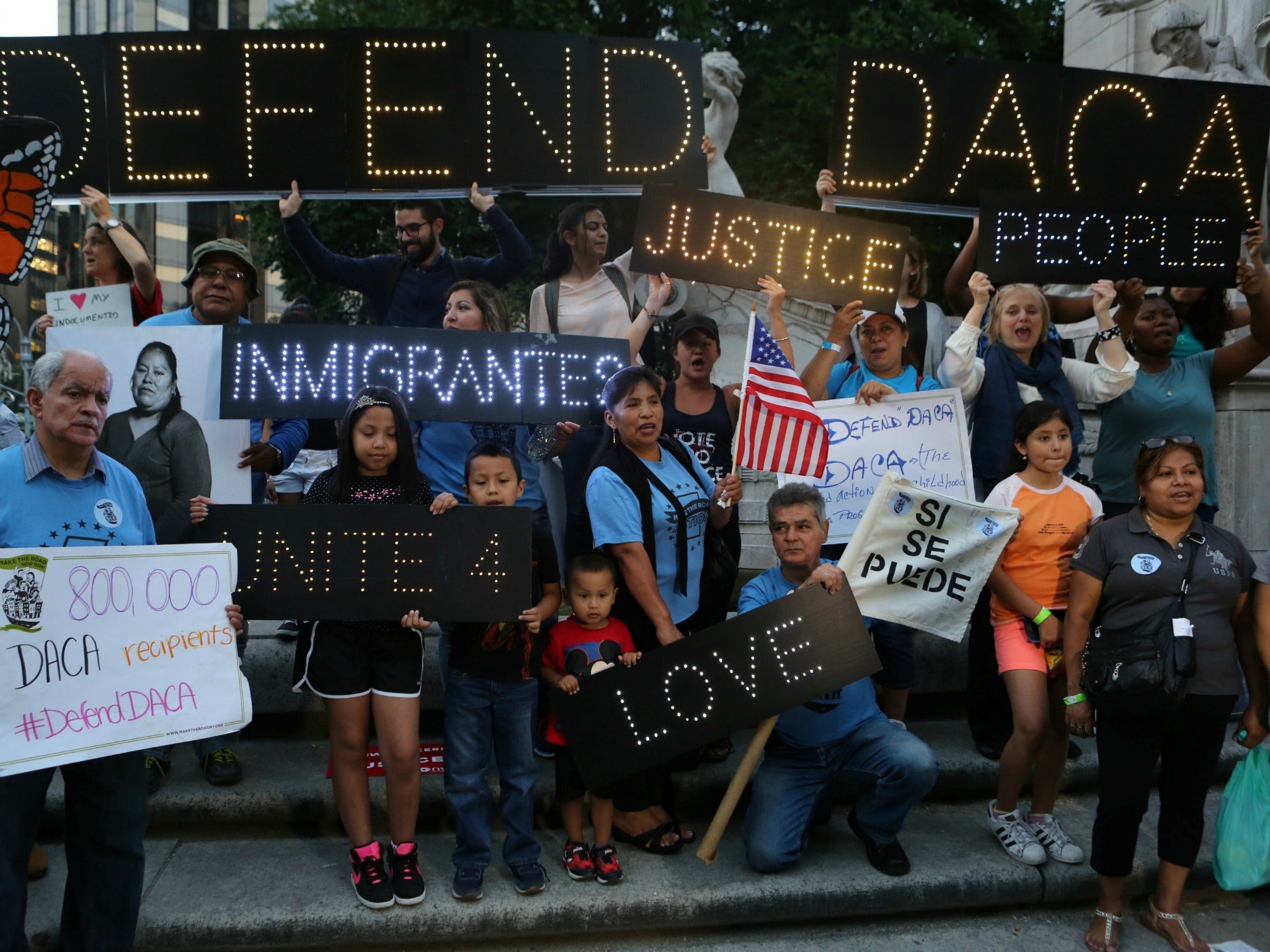 People hold signs in a New York City protest urging Donald Trump to keep the Daca programme