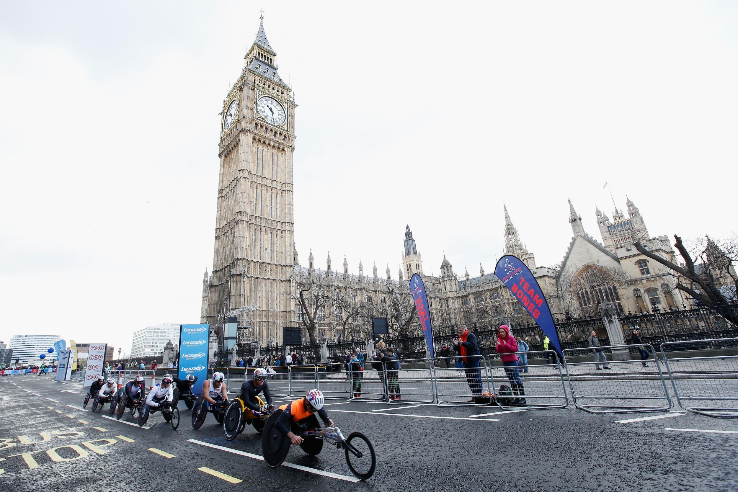The men’s elite wheelchair lead group head past Big Ben during the London Marathon – organisers permit only a dozen ordinary wheelchair racers to take part
