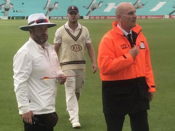 An official holds the arrow, retrieved from the cricket ground
