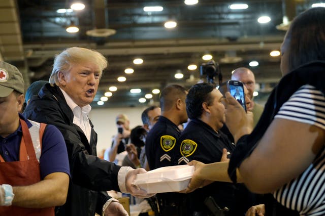 President Donald Trump passes out food and meets people impacted by Hurricane Harvey during a visit to the NRG Center in Houston