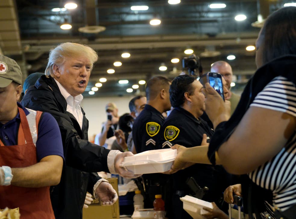 President Donald Trump passes out food and meets people impacted by Hurricane Harvey during a visit to the NRG Center in Houston