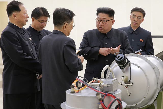 Photos released by North Korea show Mr Kim talking to subordinates next to a device thought to be the new thermonuclear weapon. There is no way of independently verifying the pictures