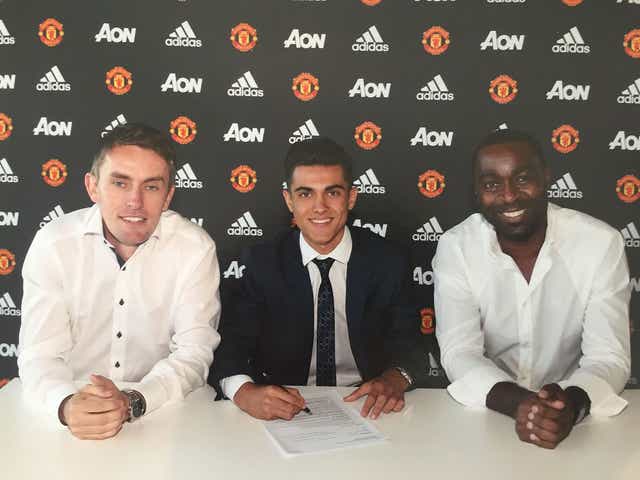 Arnau Puigmal signs his Manchester United contract alongside Kieran McKenna and Andy Cole
