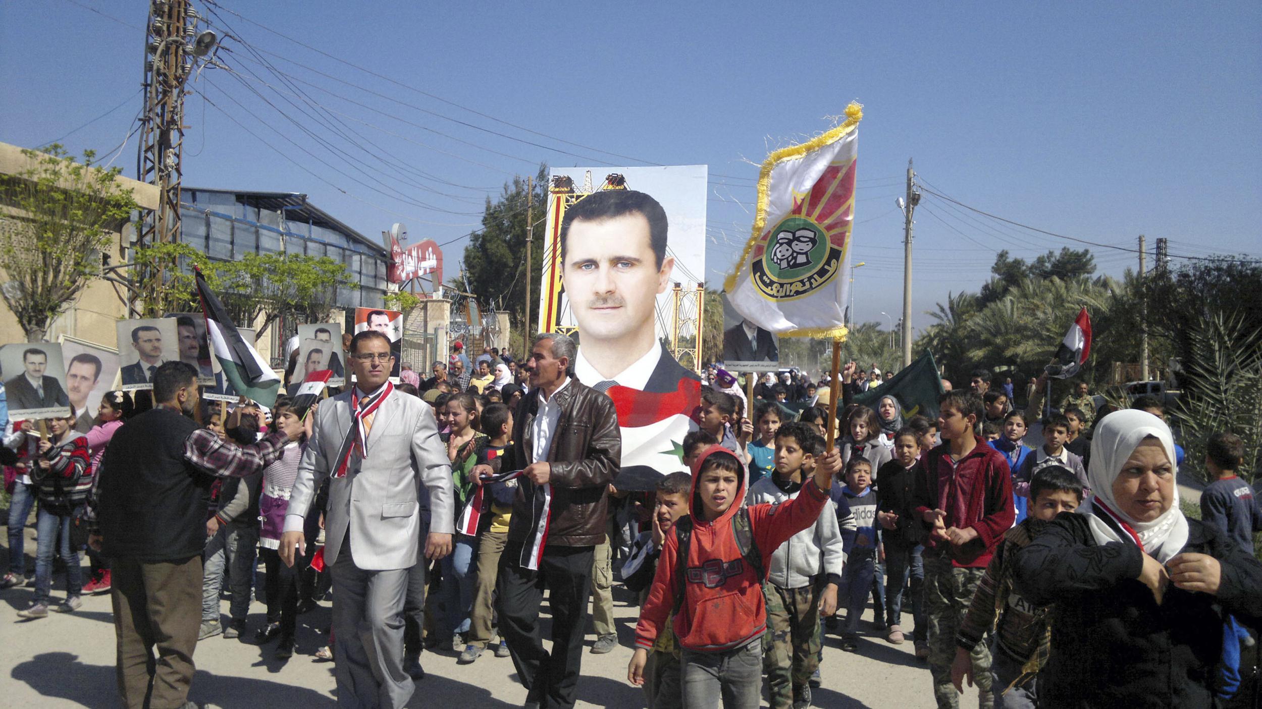 Residents in Deir Ezzor at a 2014 rally to support Syria's President Bashar al-Assad, before the town was beseiged by Isis militants