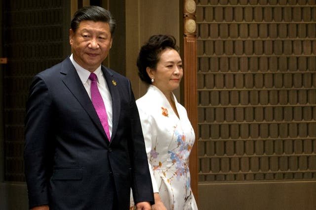 Chinese President Xi Jinping and his wife Peng Liyuan arrive at a summit with Russia, India, Brazil and South Africa in southeast China, with domestic and international issues on his mind Mark Schiefelbein/AP