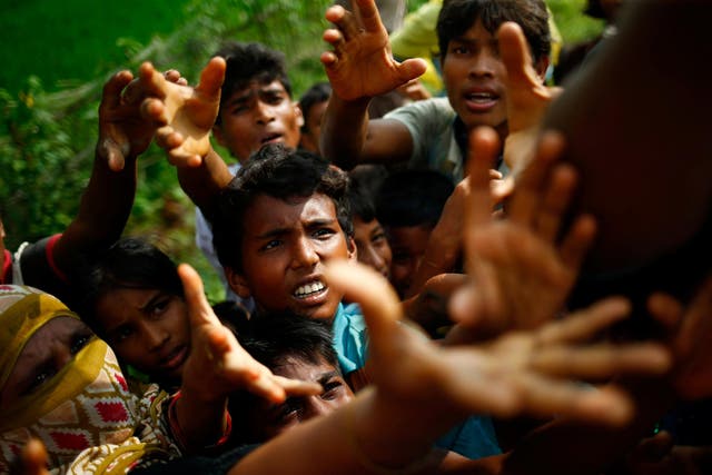 Rohingya refugees stretch their hands out for food near Balukhali in Cox's Bazar, Bangladesh