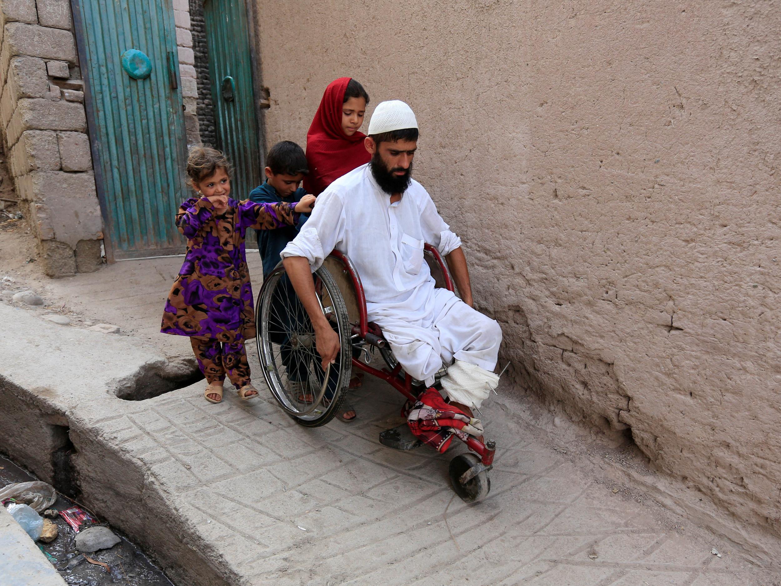 Mehrullah Safi, 28, a disabled Afghan National Army (ANA) soldier, leaves with his children from their house in Jalalabad province, Afghanistan