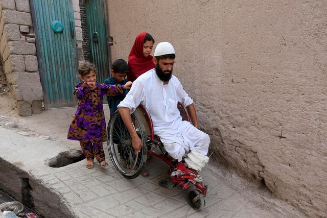 Mehrullah Safi, 28, a disabled Afghan National Army (ANA) soldier, leaves with his children from their house in Jalalabad province, Afghanistan
