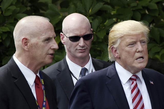 Keith Schiller (left), Deputy Assistant to the President and Director of Oval Office Operations, talks to President Donald Trump on the South Lawn of the White House in June