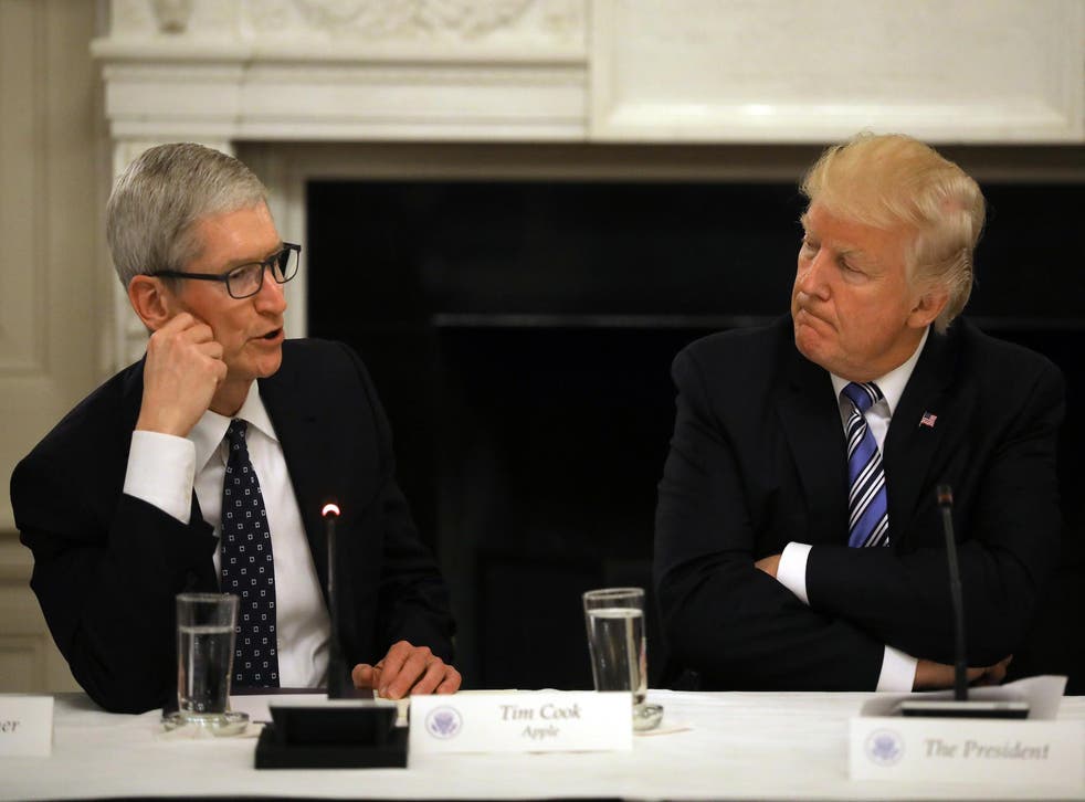 US President Donald Trump listens as Tim Cook, CEO of Apple speaks during an American Technology Council roundtable at the White House in Washington