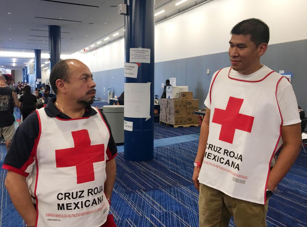 Marco Franco (left), deputy director of Mexican Red Cross disaster relief, talks with Gustavo Santillan, part of a group of 33 Mexican Red Cross volunteers helping victims of Hurricane Harvey, at the George R. Brown convention centre in Houston, Texas