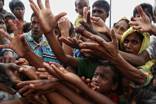 Rohingya refugees reaching for food aid at Kutupalong refugee camp in Ukhiya near the Bangladesh-Myanmar border on 30 August 2017