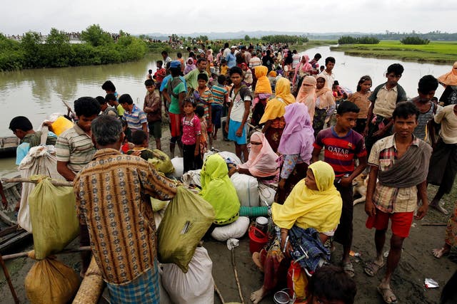 Rohingya refugees are seen waiting for a boat to cross the border through the Naf river in Maungdaw, Burma