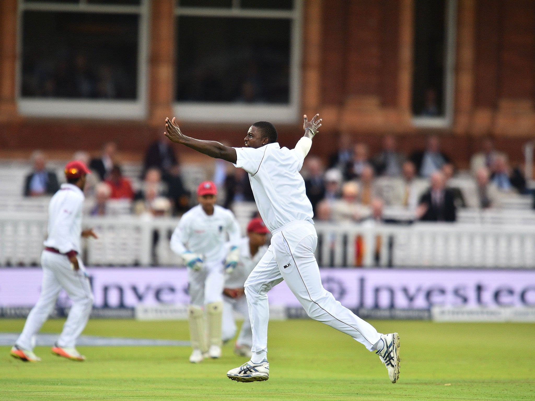 Jason Holder celebrates taking the wicket of Joe Root