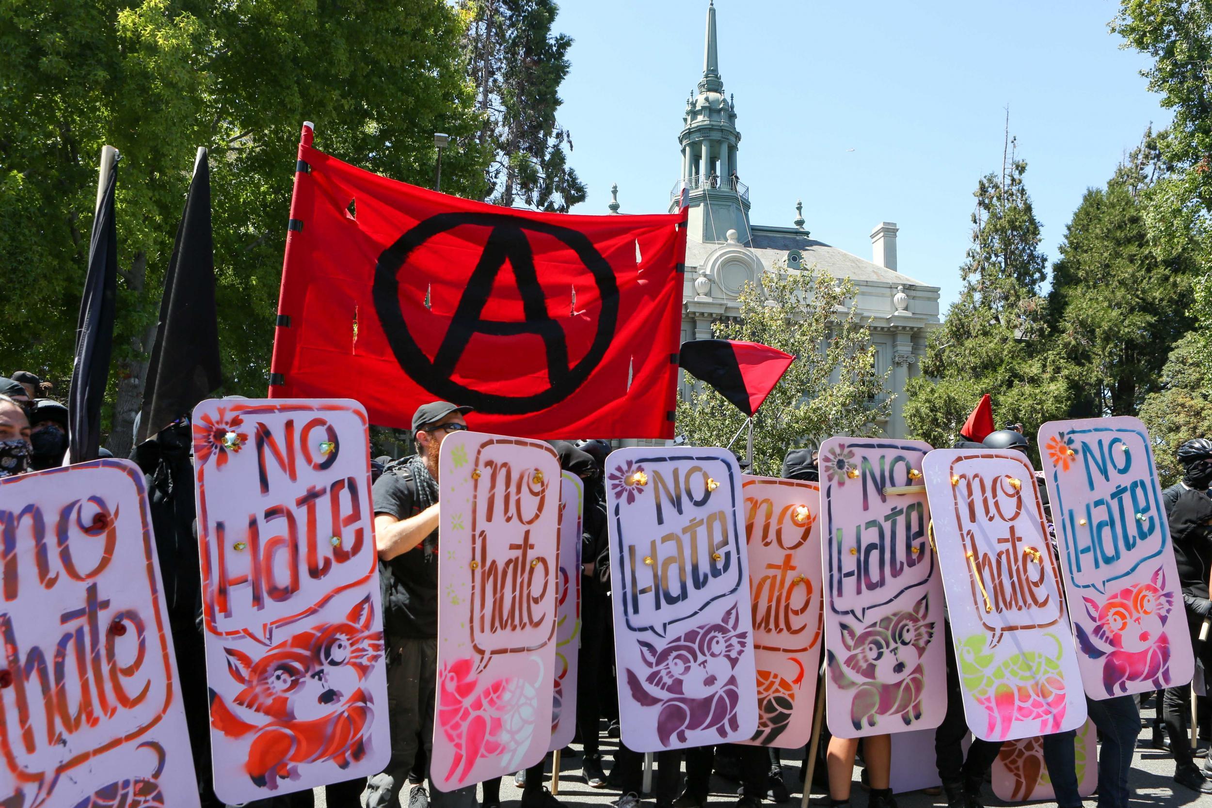 The anarchist flag flies over Antifa activists and counter protesters in Berkeley (AFP/Getty)