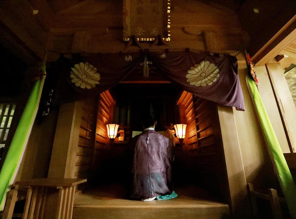 A Shinto priest holding a ritural ceremony at Okitsugu shrine of the Munakata Taisha in Okinoshima island